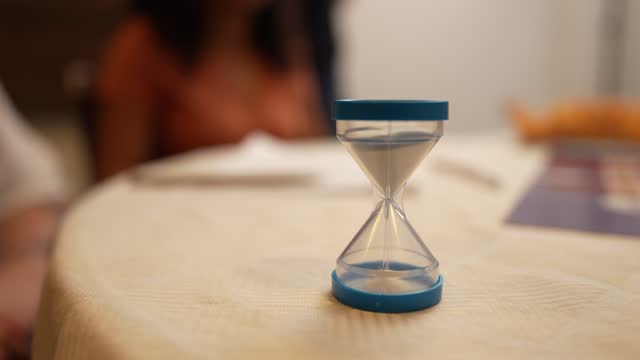 Small game hourglass sand timer being turned