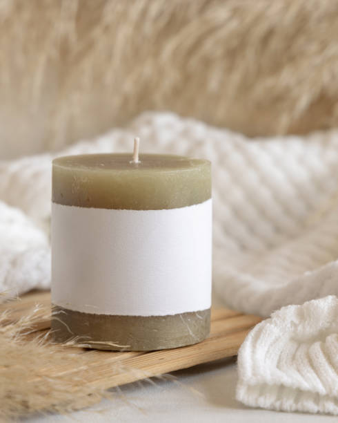 istock Candle with label on white table with dried pampas grass, Close up, copy space. Packaging mock up 1492902291