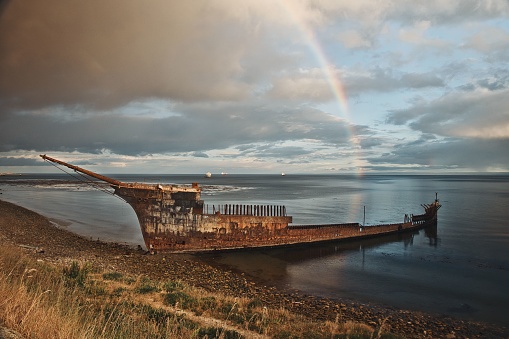 An abandoned ship moored in the tranquil waters of a lake in Punta Arenas
