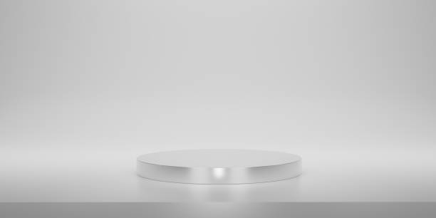 istock Shiny silver round pedestal or podium  with studio backdrops. Metallic white  Blank display or clean room for showing product. Minimalist mockup for podium display or showcase. 3D rendering. 1492903138