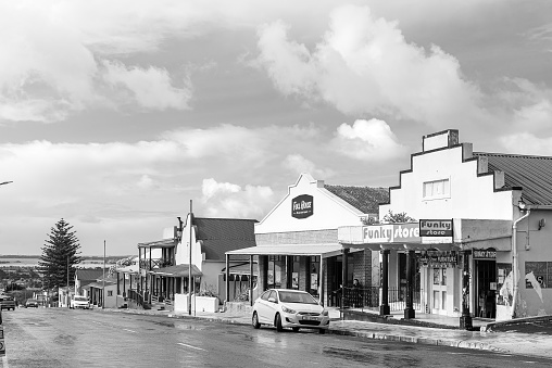 Bredasdorp, South Africa - Sep 23, 2022: A street scene, with businesses, in Bredasdorp in the Western Cape Province. Vehicles are visible. Monochrome