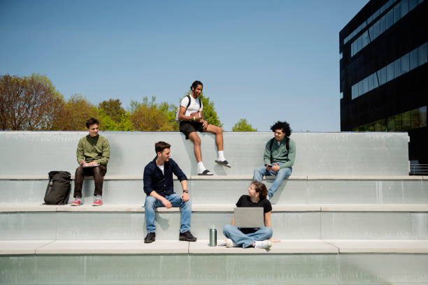 istock Group of college students relaxing outdoors on building rooftop. 1492906162