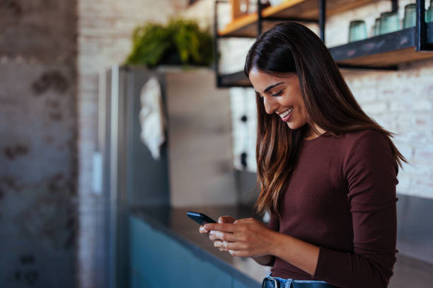 istock Portrait of young woman smiling while using smartphone. 1492906356