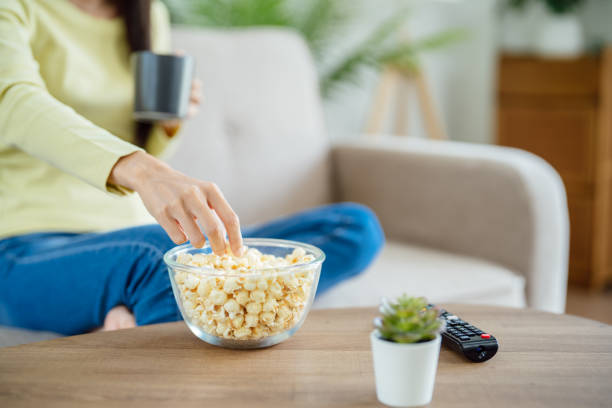 istock Asian woman Watching smart TV and using remote controller Hand holding television audio remote control at home with the remote control television 1492907344