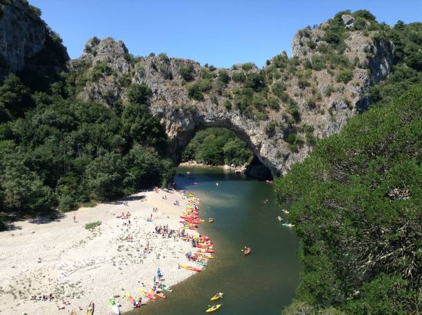 istock Pont d'Arc rock archway with canoes and tourists sunbathing 1492910723