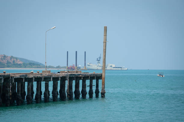 The seaside jetty or boat pier in sunny day with background of the island as far away. Transportation building in the outdoor. Selective focus.