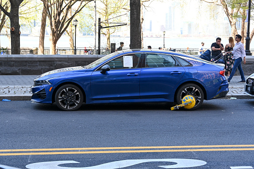 New York, USA, April 13, 2023 - A parking claw  placed by the New York Police Department on a parked car at River Terrace, New York.