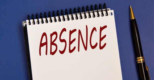 istock ABSENCE - word in a white notebook on a blue background with a pen 1492917299