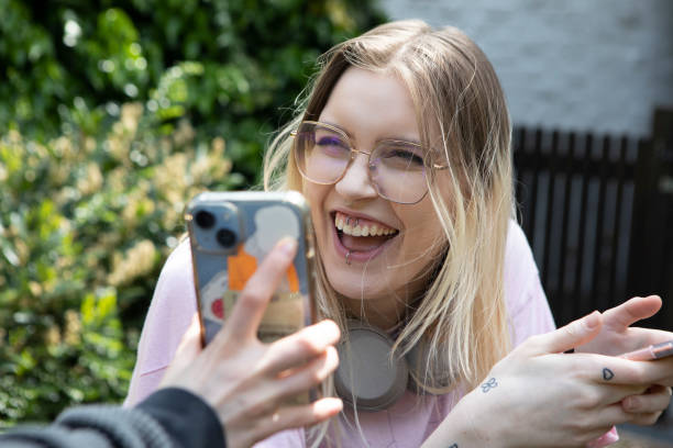 istock Young female laughing with a smart phone 1492919458