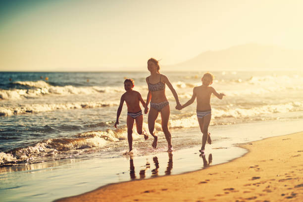 istock Happy children running on the beach on sunset 1492922174