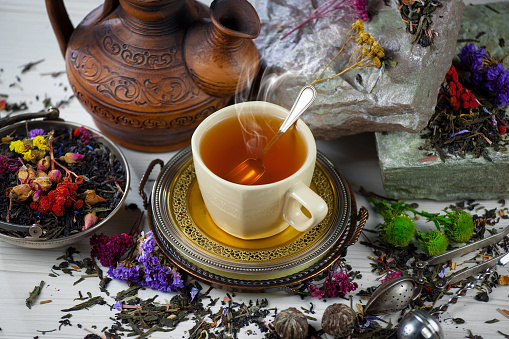 Hot drink tea in a cup, in a composition with accessories, on an old background