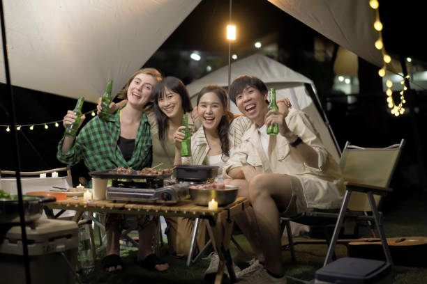 istock Group of young people enjoy eating and drinking while camping. 1492927312