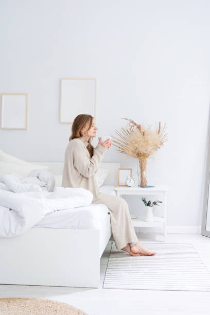 istock Woman sitting at bed at home drinking coffee 1492928065