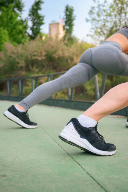 istock Couple doing stretching exercises in a park. Legs close-up. 1492929871