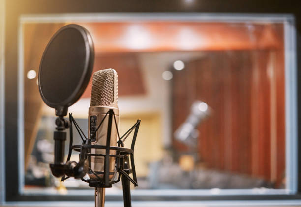 istock Microphone, studio and music with equipment at a record label for recording audio or sound for the radio. Singing, creative and art with a mic in an empty room for live streaming or production 1492930285
