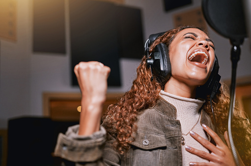 Music, singing and recording studio with a black woman celebrity at her record label to sing a song for her new album. Creative, art and performance with a female singer streaming live on the radio