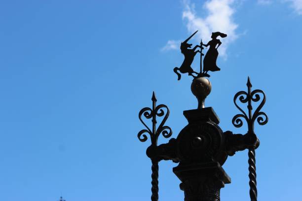 An impressive large metal statue stands tall with a decorative top piece