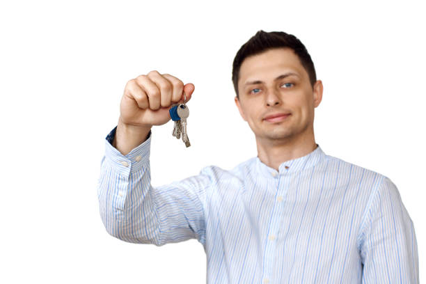 istock caucasian man holding keys on white background. 1492932439