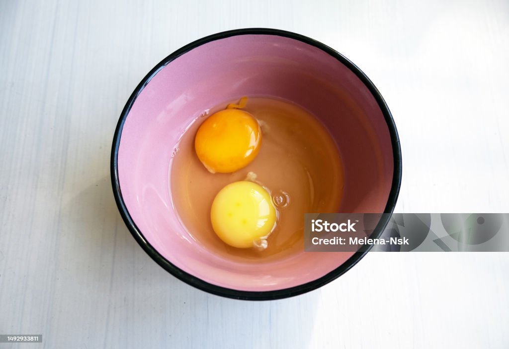 Duas gemas de ovos de cores amarelas diferentes em um prato. Ingrediente para cozinhar e assar - Foto de stock de Amarelo royalty-free Duas gemas de ovos de cores amarelas diferentes em um prato. Ingrediente para cozinhar e assar - Foto de stock de Amarelo royalty-free