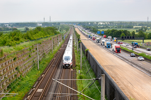 Floersheim, Germany - May 22, 2023: Large road construction site and dense traffic on German highway A3 between Raunheim and Wiesbadener Kreuz. Passing high speed ICE train