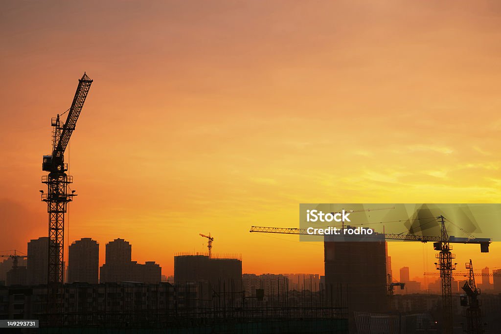 Silhouette of  tower cranes on the construction site. Silhouette of the tower crane on the construction site with city building background Architecture Stock Photo