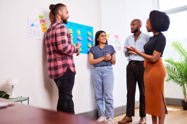 istock Scrum team participates in daily stand up on KANBAN board, mobile app developers 1492937881