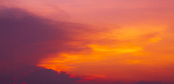 Clouds and orange sky,Real majestic sunrise sunset sky background with gentle colorful clouds without birds.Panorama, large