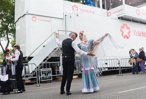 Madrid, Spain; May 14, 2023: Adult couple dancing chotis and pasodobles, dressed in the typical and traditional costumes of Madrid, Spain; on the feast of San Isidro.