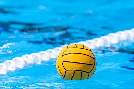 Yellow water polo ball on swimming pool surface for game, competition and practice for match. Horizontal sport theme poster, greeting cards, headers, website and app