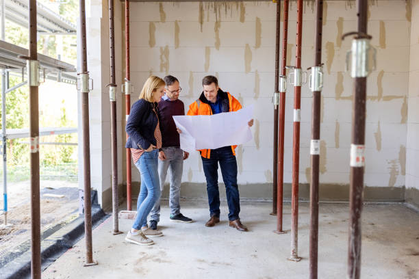 istock Engineer showing building plan to a couple at construction site 1492941394