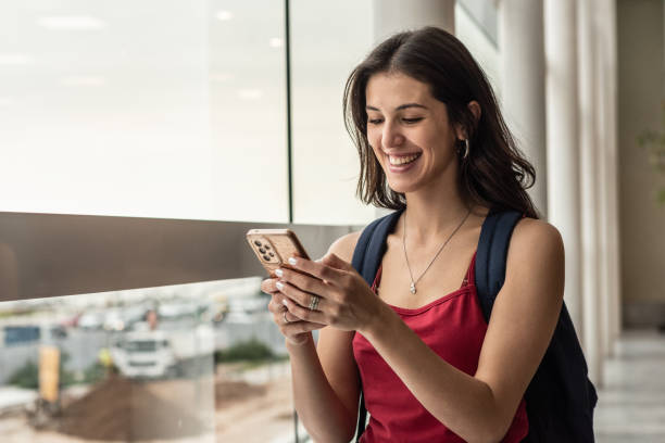 istock Young woman using a mobile phone at airport 1492942549