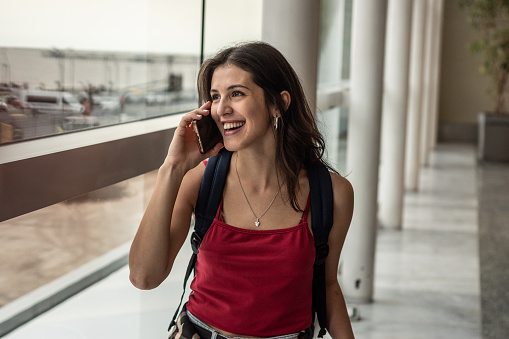 Young woman talking on mobile phone at airport