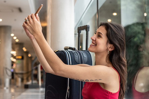 Young woman taking a selfie while waiting at airport