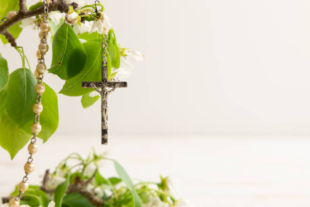 Rosary hanging on branch with white flowers stock photo