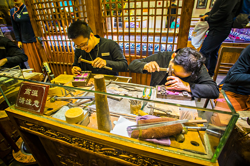 Workers in a shop in Yuyuan Garden Market, Ancient Chinese architecture at night in Yuyuan, which is the old town city center of Shanghai, China.