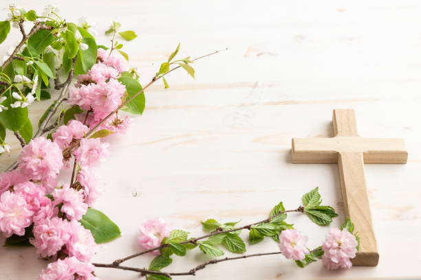 istock Wood cross with branch with pink blossoms 1492942908