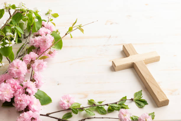 istock Wood cross with branch with pink blossoms 1492942910