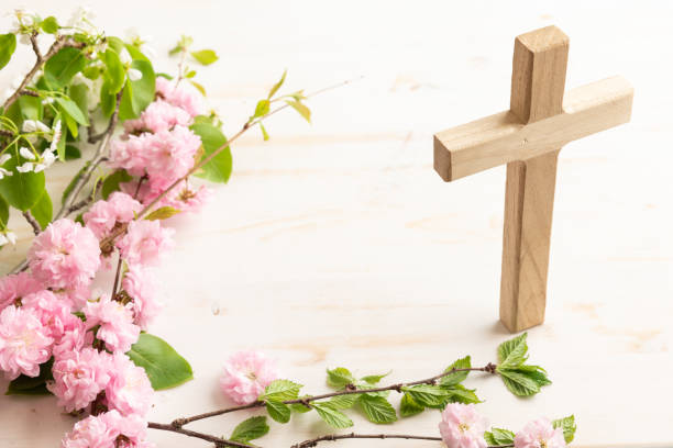 istock Wood cross with branch with pink blossoms 1492942924