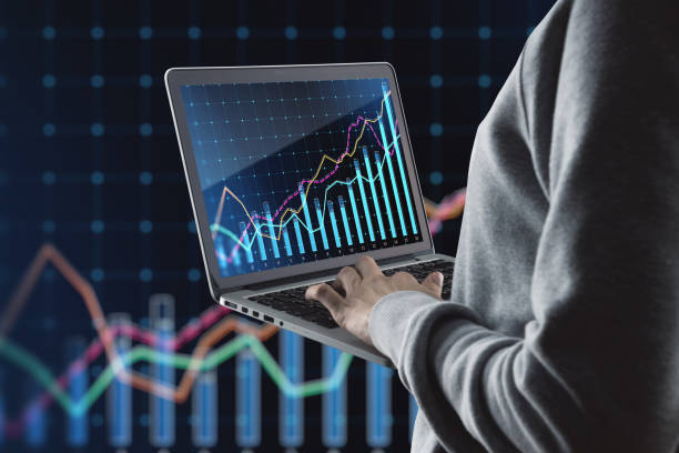 istock Businessman hand holding laptop with growing business chart grid on blurry background. Corporate growth plan and company development concept. 1492944754