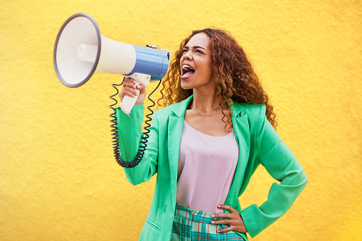 Megaphone, woman and shouting on yellow background of speech, broadcast and protest noise. Female, announcement and screaming voice for justice, news and attention of opinion, gen z speaker and power