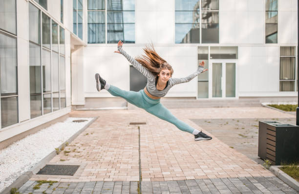istock Young female dancer practicing different types of jumps with her leg in split 1492949652