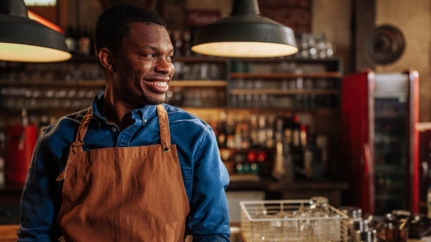 istock Close portrait of happy bartender smiling and looking aside. 1492953729