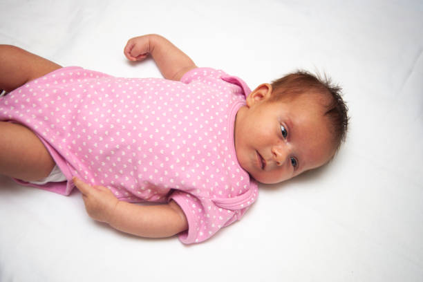 Baby girl in pink cloth on white background.