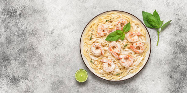 spaghetti-nudeln mit garnelen-scampi auf hellem hintergrund. draufsicht, flat lay, kopierraum, banner. italienisches und mediterranes essen. - scampi stock-fotos und bilder