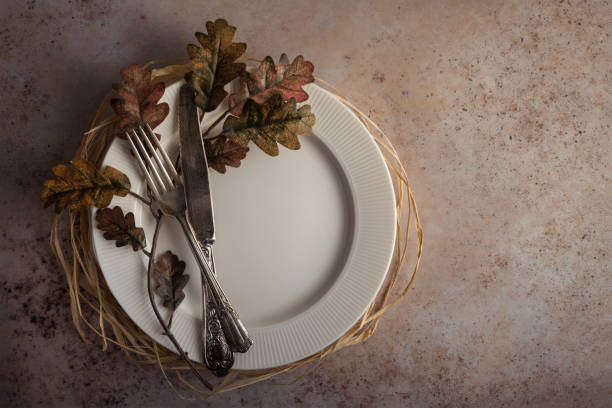 istock Round empty plate with oak leaves and cutlery top view 1492957577