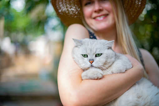 Young Woman Holding British Shorthair Cat in the Garden