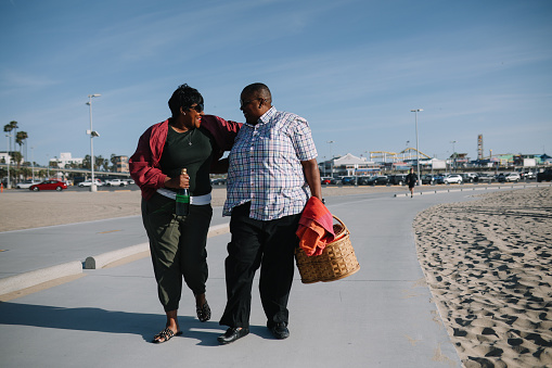 LGBTQ couple enjoying their time together on the Santa Monica beach, walking, spending a nice and relaxed afternoon.