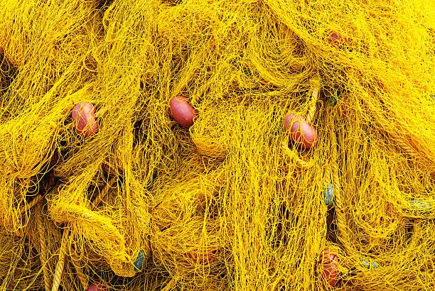 Yellow fishingnet with red floaters in greek harbour