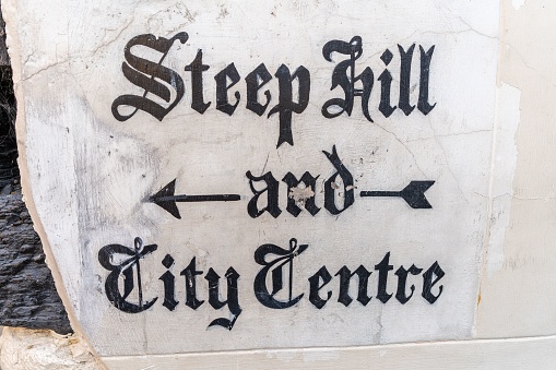 Quaint historic stone carved sign on a wall in Lincoln,  UK directing people down Steep Hill