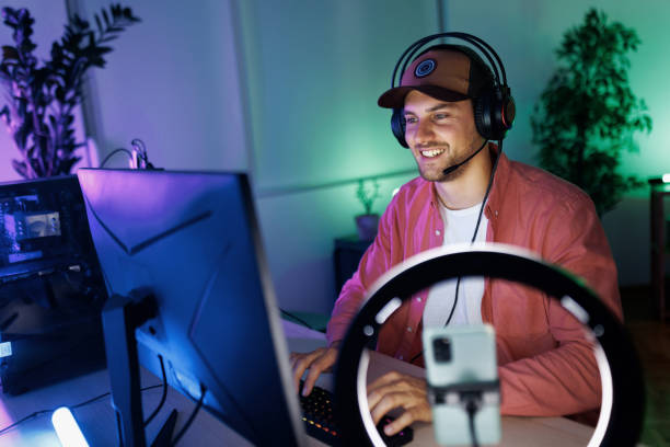 istock Smiling handsome man playing video games on desktop PC at home 1492971818